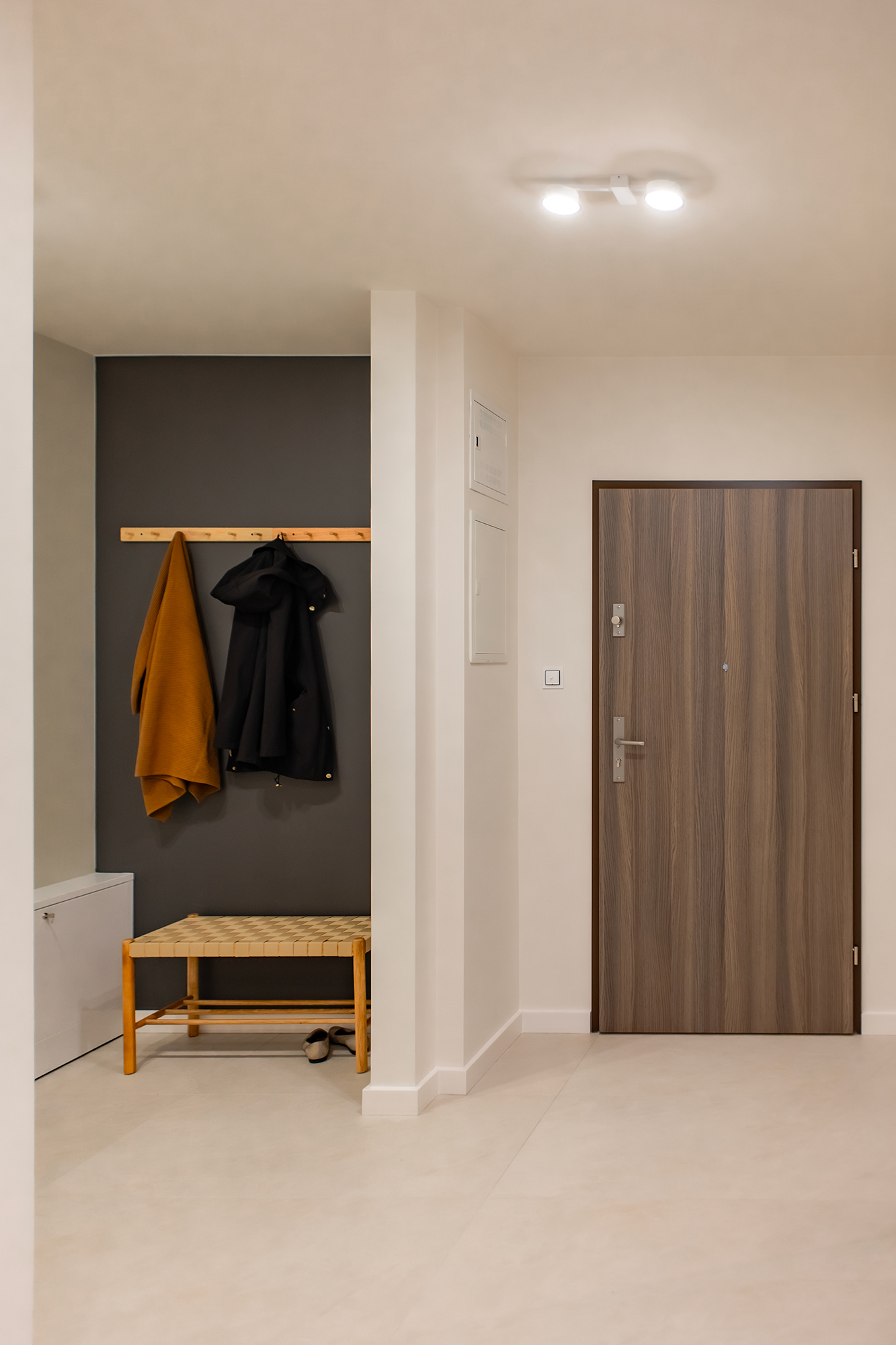 Dzięki skróceniu długiej i niefunkcjonalnej wnęki w korytarzu, zostały poprawione proporcje mieszkania. Fotografia na ścianie jest autorstwa Mateusaz Gzika z Decotive.